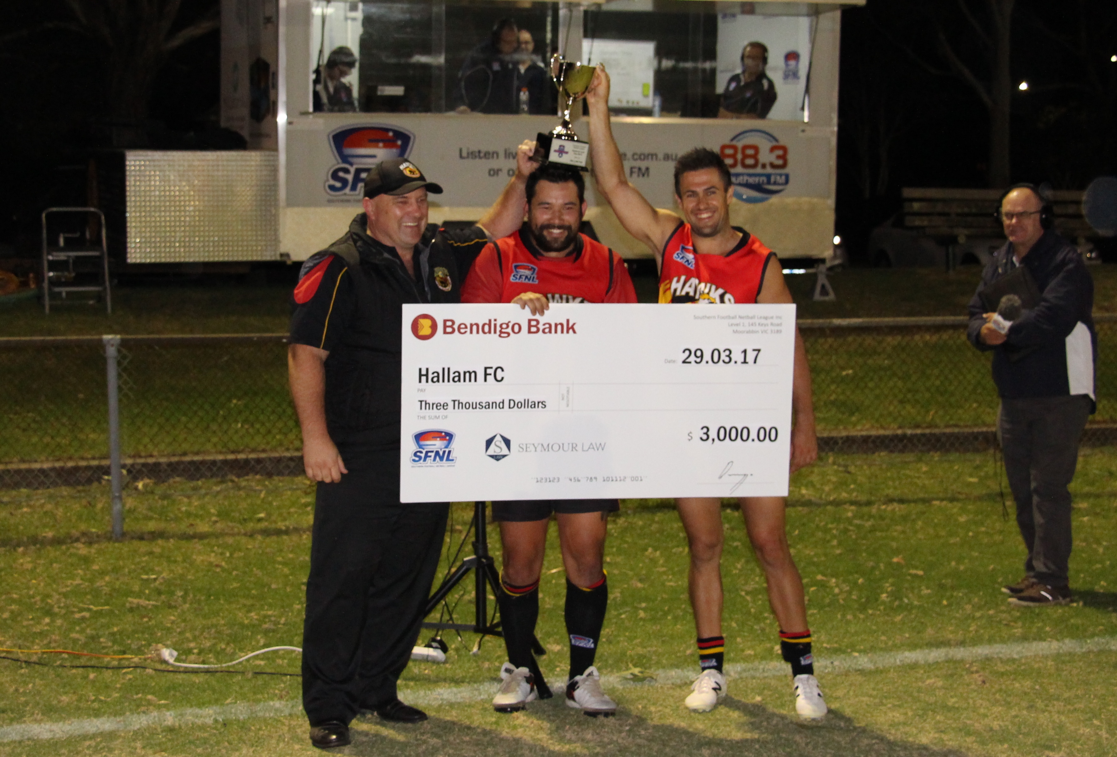 Hallam coach Scott Slater and co-captains Manny Peresso and Stephen Chin are present with the trophy and $3000 cheque.